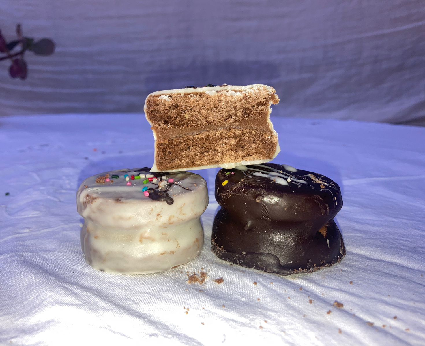 Alfajores rellenos con dulce de leche, cubiertos de chocolate y decorados a mano.