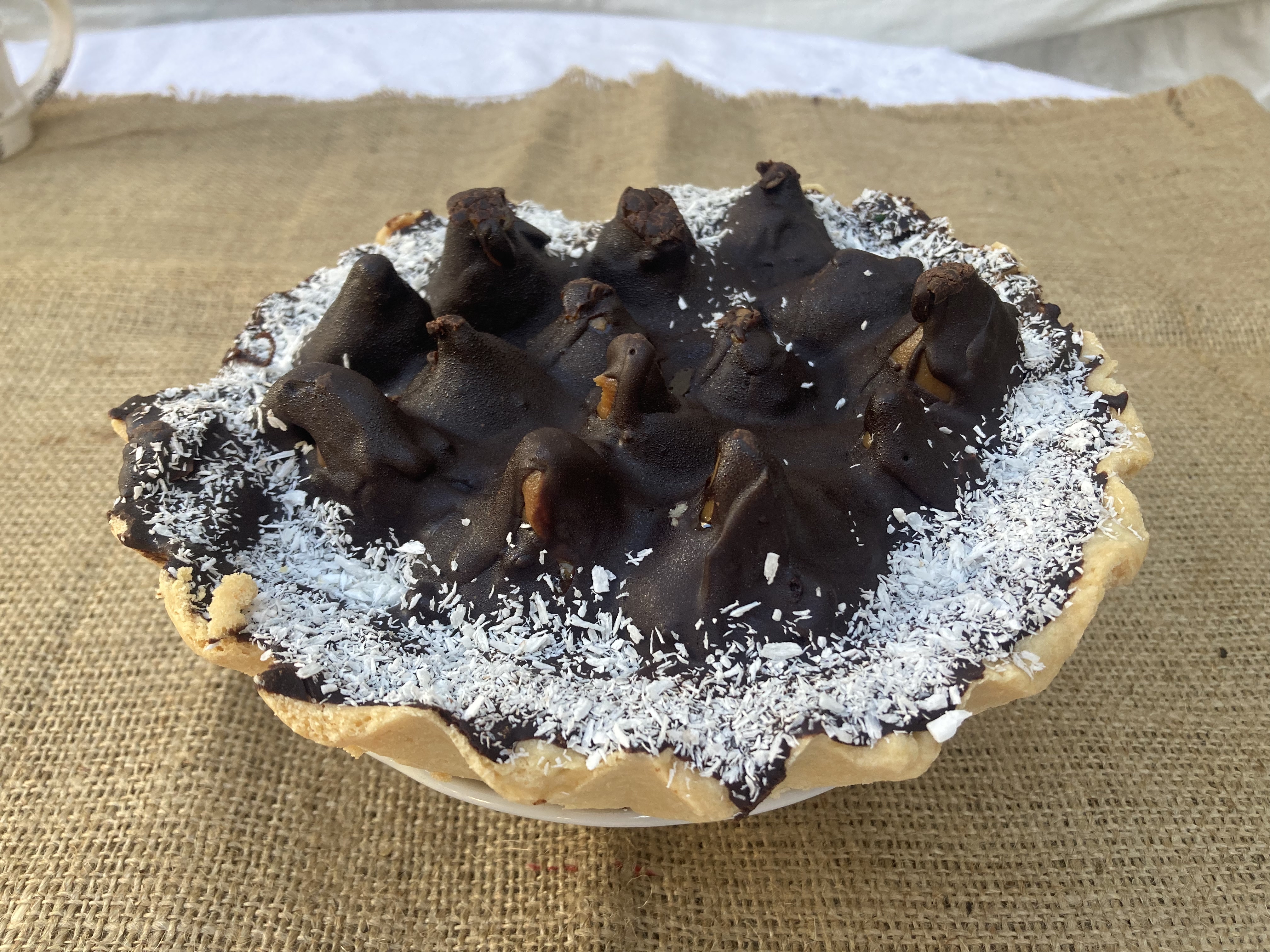 Torta de dulce de leche con decoración temática de copos de chocolate, perfecta para los fanáticos del chocolate.